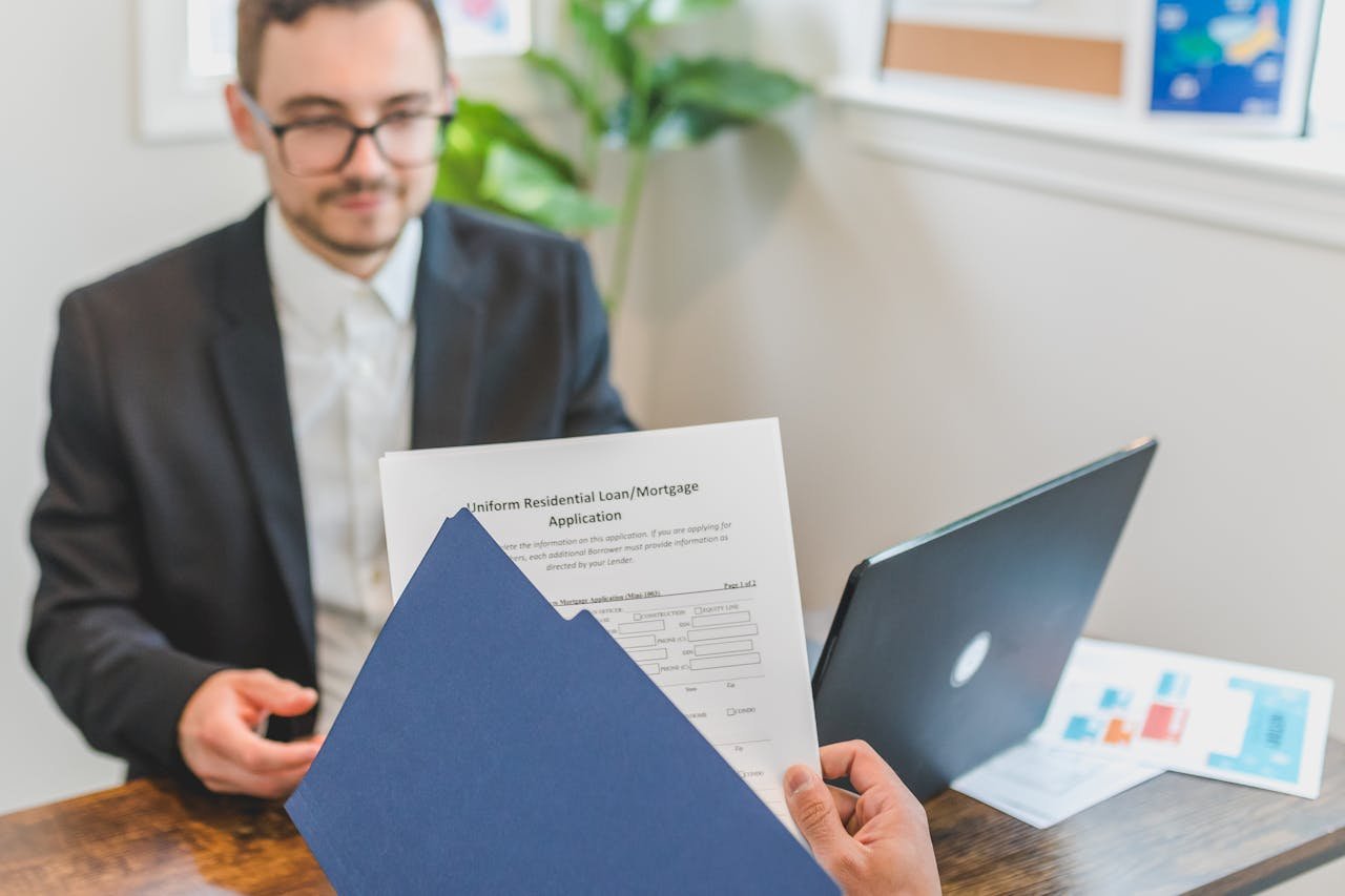 The Art of Drawing Readers In: Your attractive post title goes here Mortgage broker and client discussing loan application with documents on table.